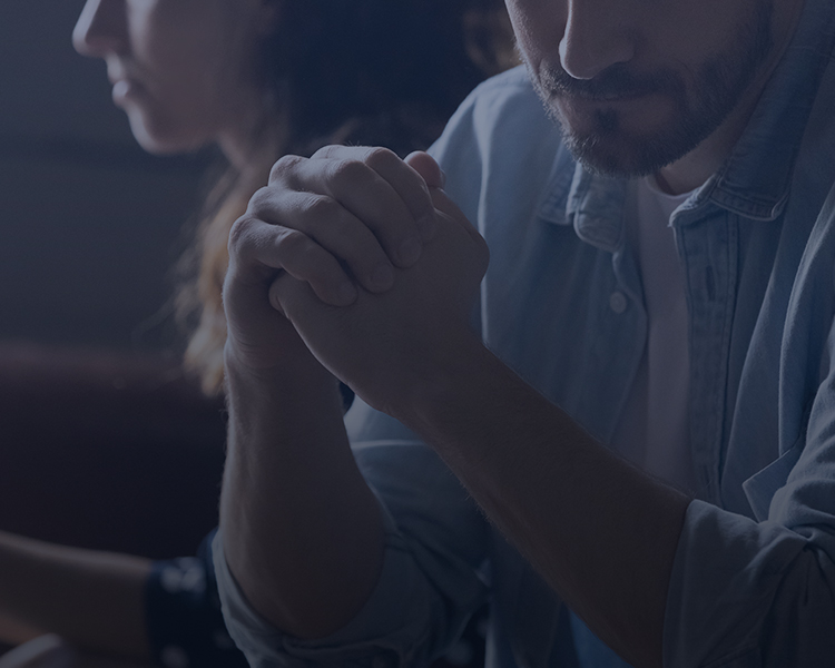 A worried man and woman sit together, sharing a moment of concern.