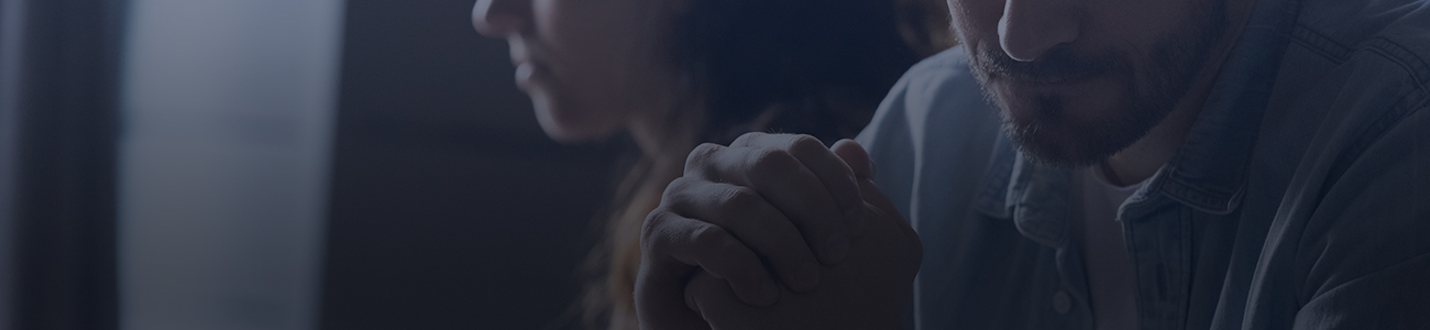 A worried man and woman sit together, sharing a moment of concern.