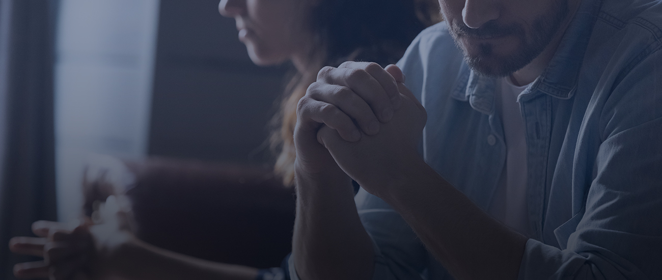 A worried man and woman sit together, sharing a moment of concern.
